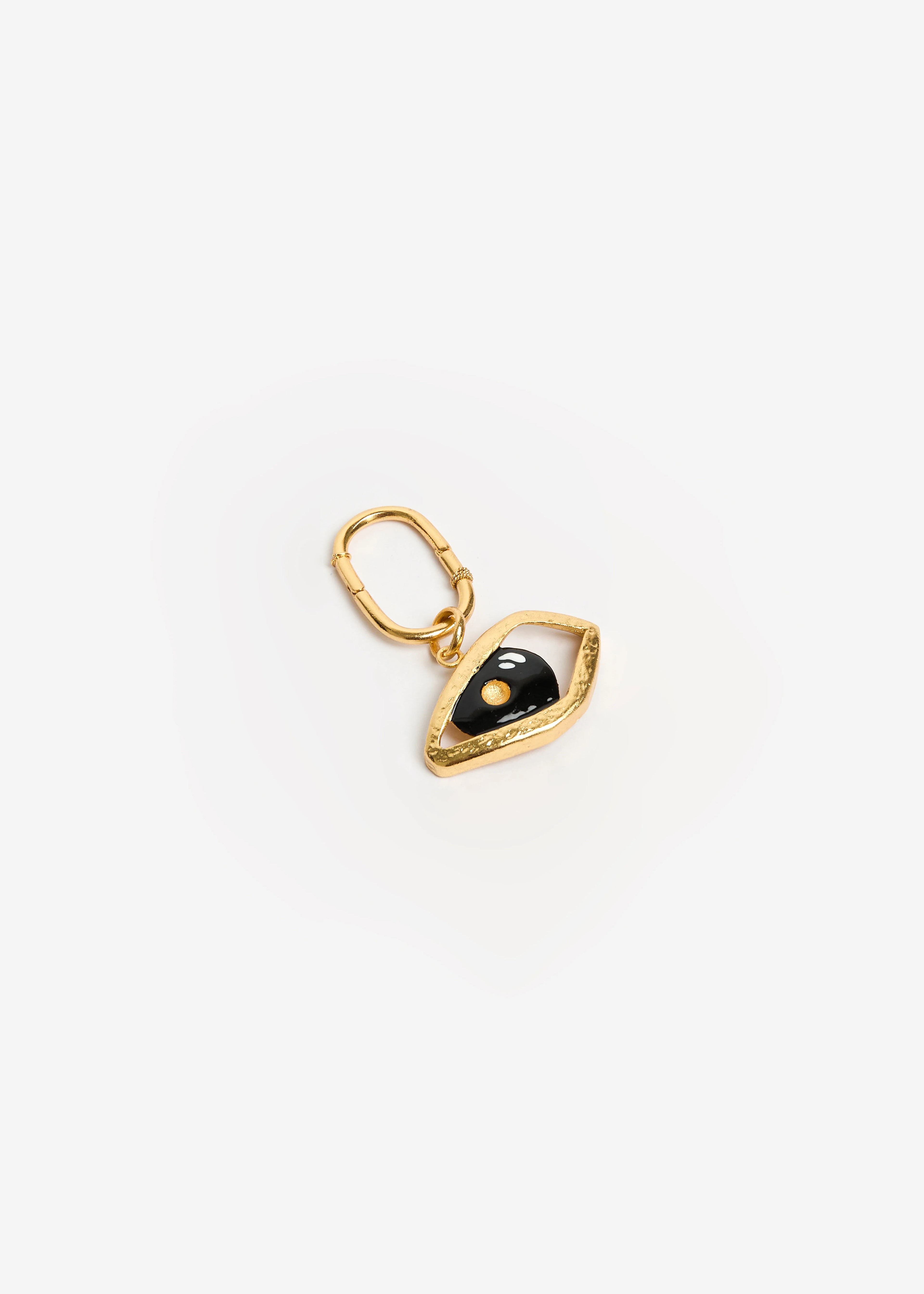 El ojo como amuleto — una mirada que protege, observa y conecta. Hecho por joyeros de tradición en Bucaramanga, Colombia. Utilizando bronce con baño en oro de 24k, esmaltes cerámicos