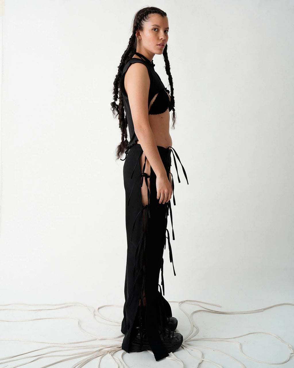 Es una pieza en la que a partir de la exageración de sus nudos, se revela el caos de lo visceral y el nudo como apego, fuerza, amarre y cercanía. Esta pieza está confeccionada con un drill 100% algodón reciclado. Es un pantalón ajustable debido a sus nudos.