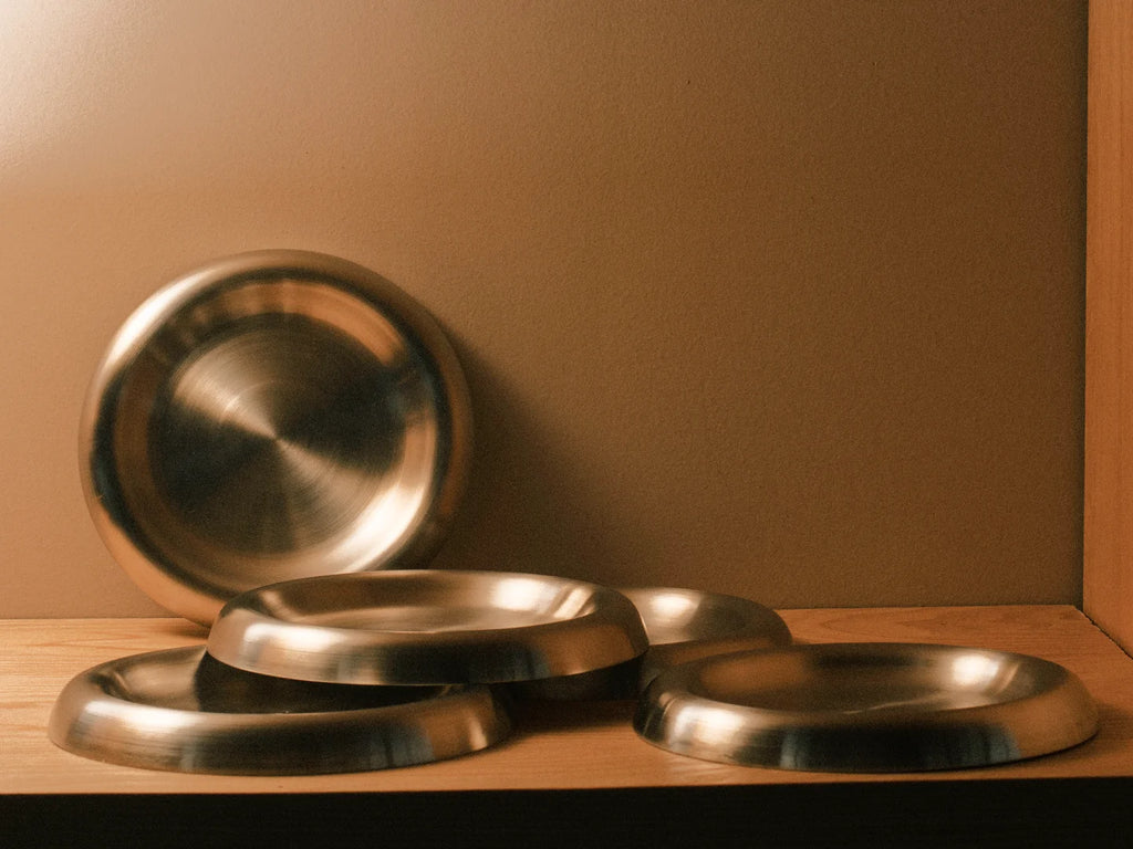 Platos curvados a partir de molde industrial, con un borde cilíndrico que enmarca su perímetro.
FÁBRICA OBJETUAL