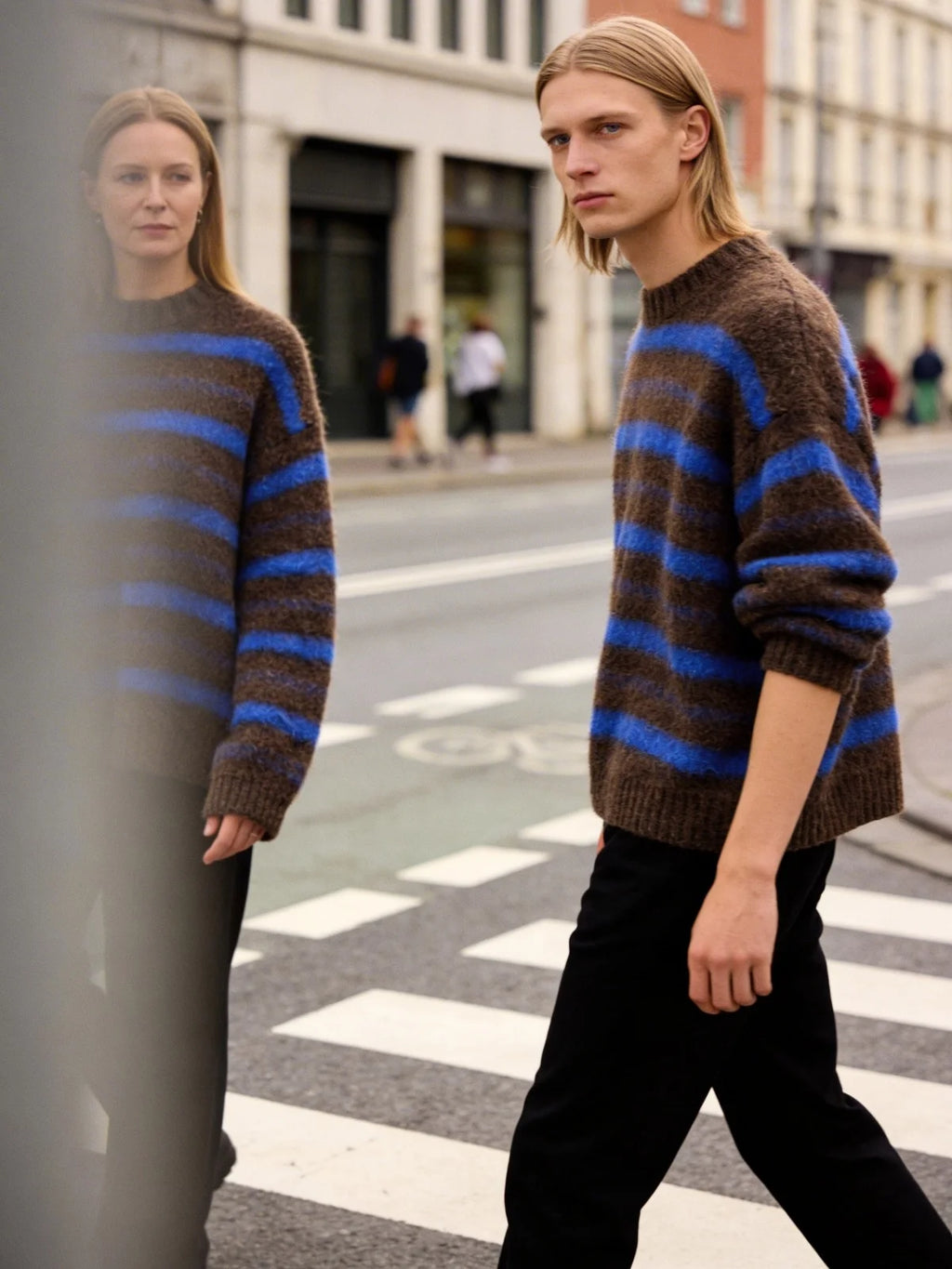 Model wearing a brown and blue striped jumper styled in an urban setting