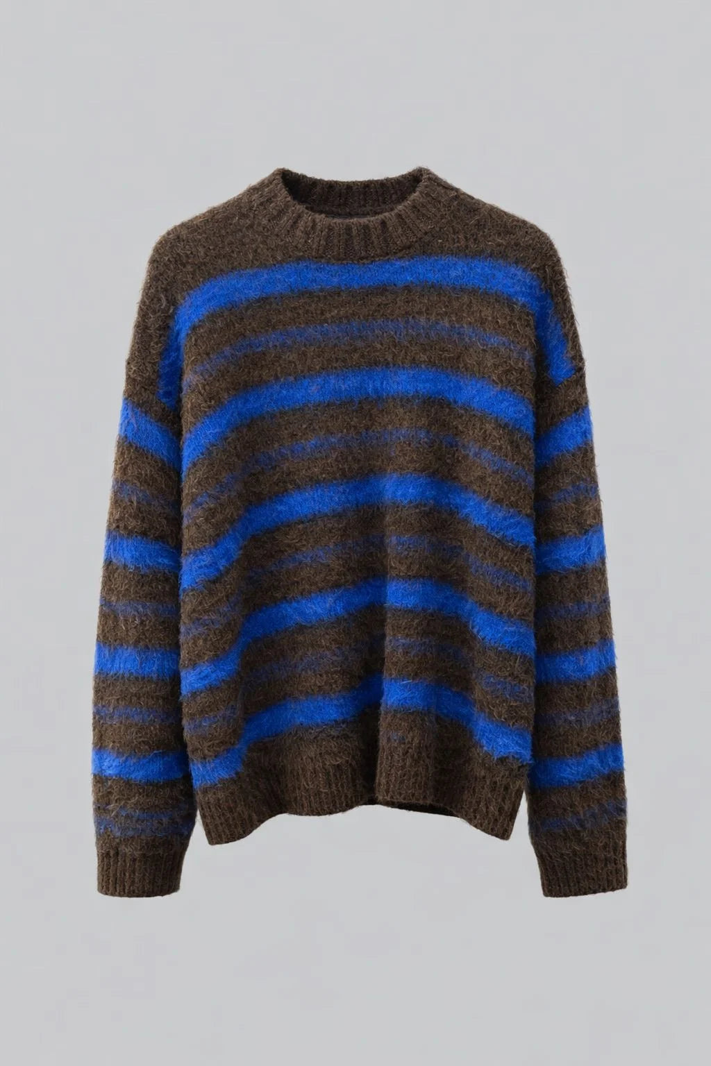 Model wearing a brown and blue striped jumper styled in an urban setting